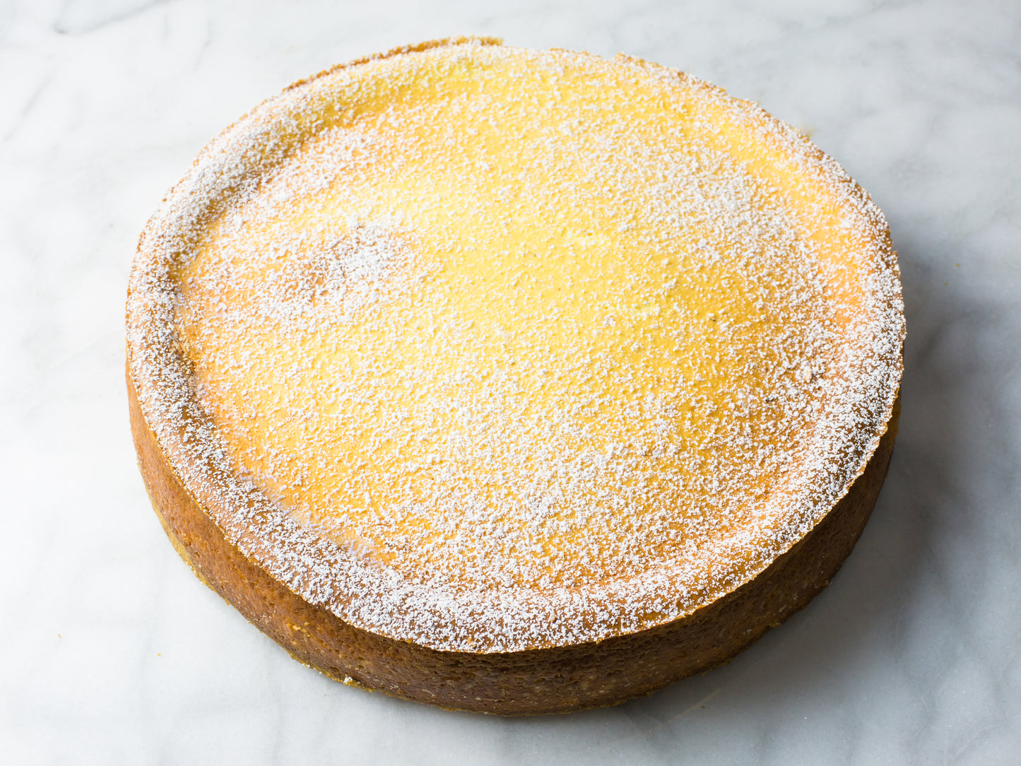 classic italian ricotta cheesecake dusted with powered sugar made by new york bakery la roma pastry shop