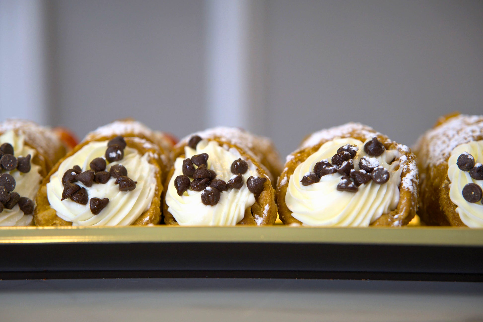 Close up image of mini chocolate chips at the end of each cannoli made by La Roma Pastry Shop