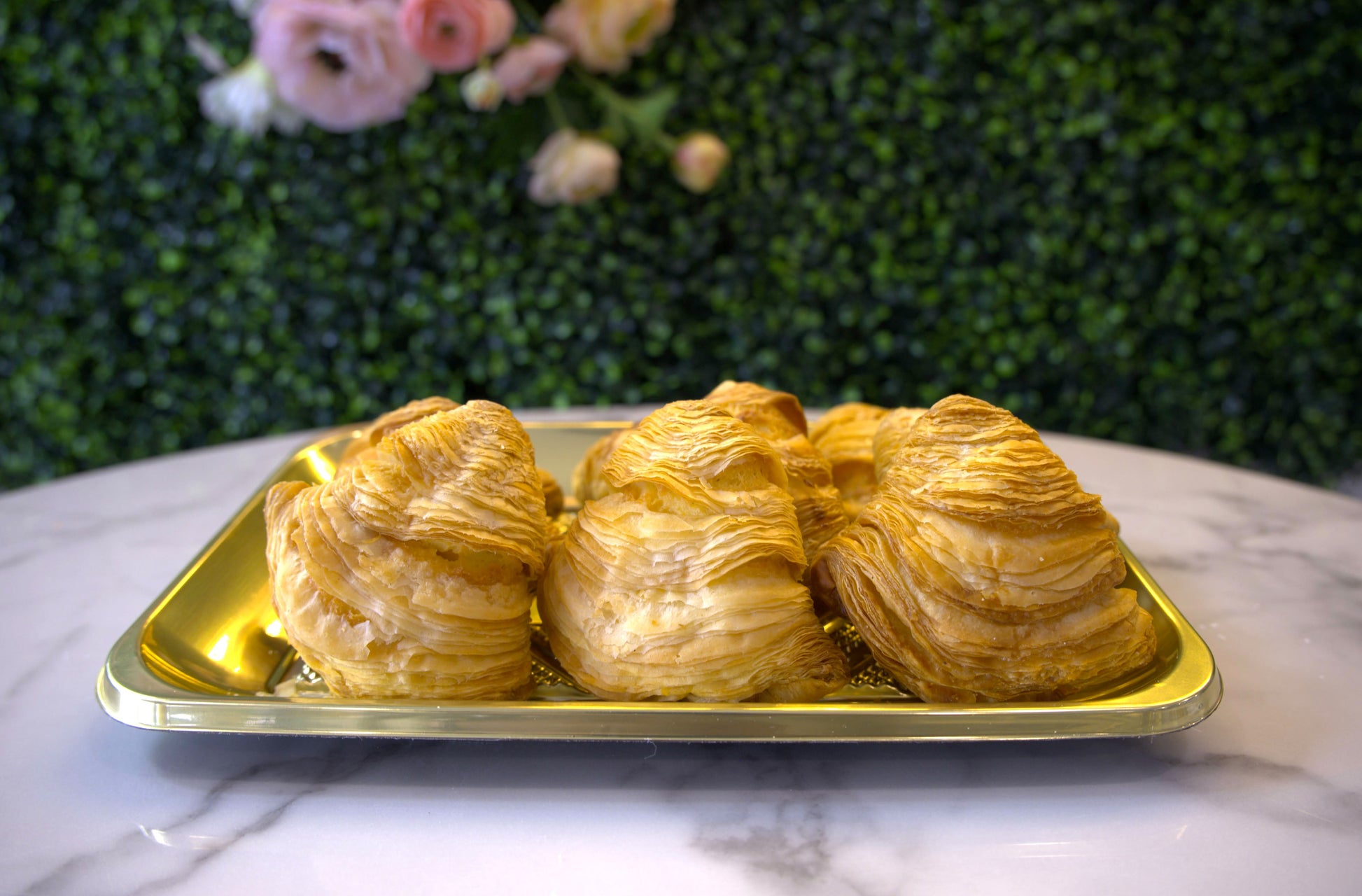 Presentational shot of sfogliatelle from La Roma Pastry Shop with floral background