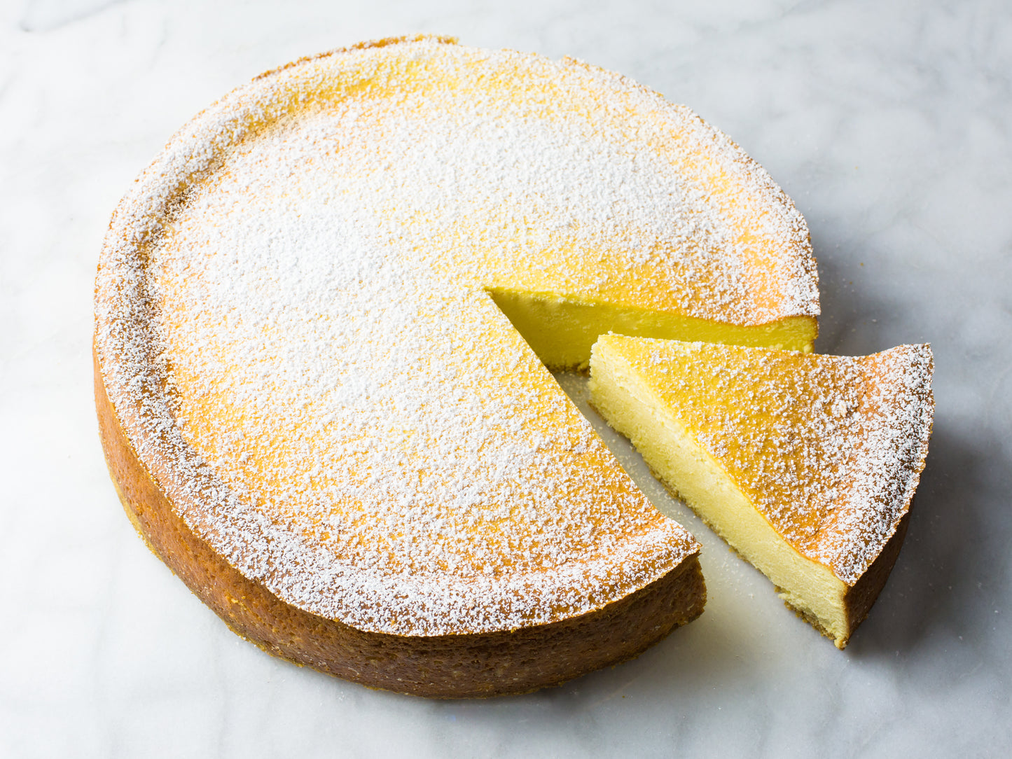 iconic italian ricotta cheesecake baked by la roma pastry shop in new york dusted with powdered sugar with slice cut out