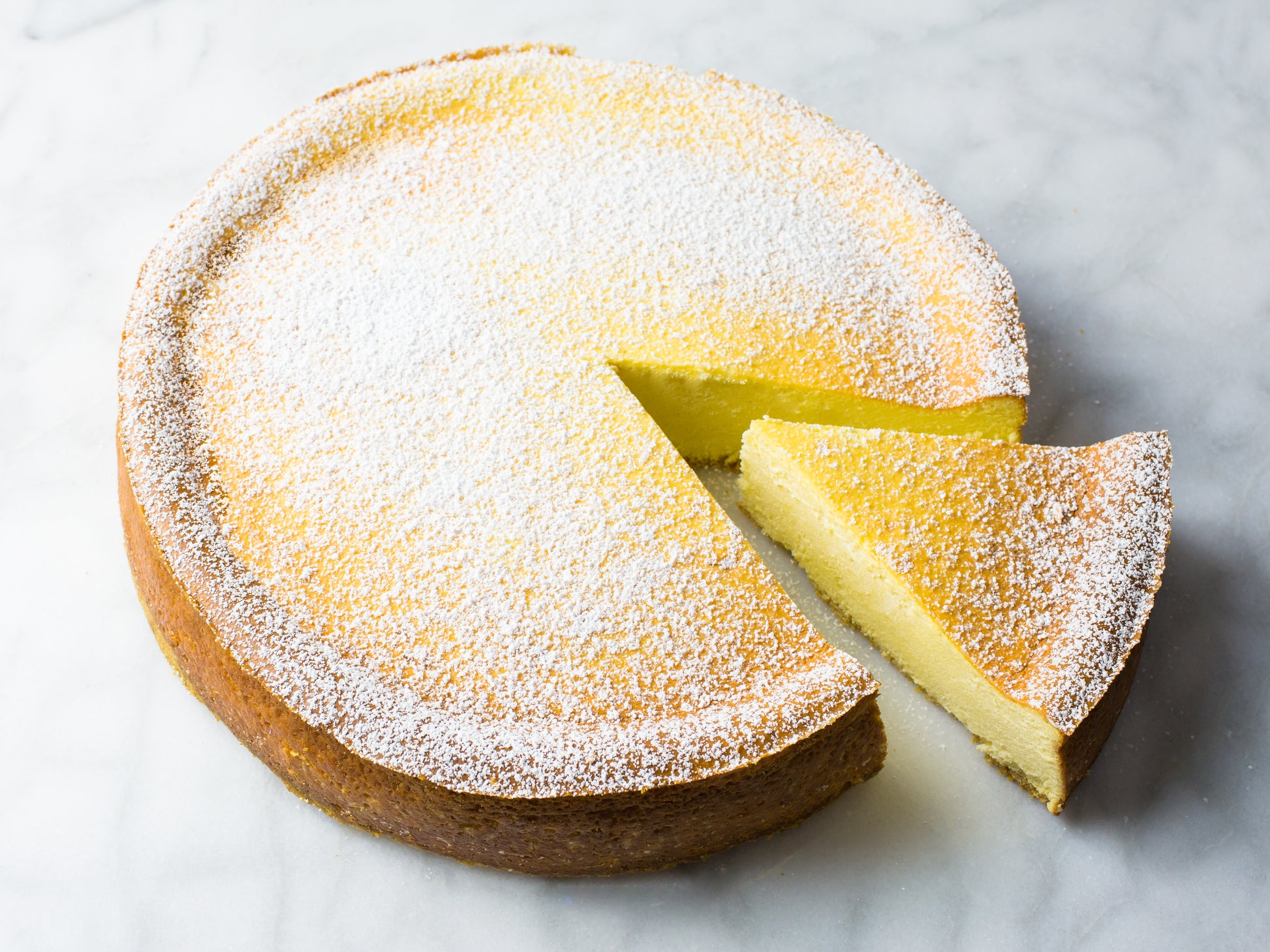 iconic italian ricotta cheesecake baked by la roma pastry shop in new york dusted with powdered sugar with slice cut out