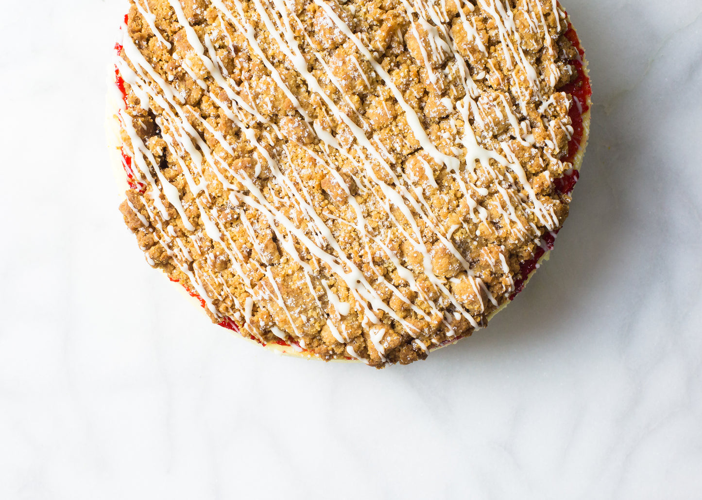 raspberry crumb cheesecake with glaze drizzle made on long island by la roma pastry shop