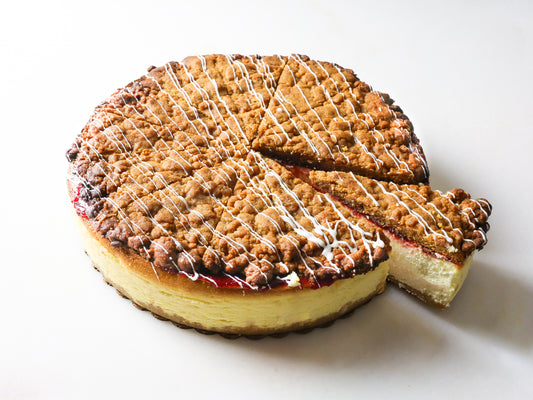 raspberry crumb cheesecake made by la roma pastry shop in oakdale new york with glaze drizzle and cut slices
